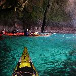 Geopark Shetland - Scotland. Site Name: Kayaking, Muckle Roe. Sea-kayaking is a popular activity around Shetland's coastline. Exploring one of a multitude of caves, such as this one in the granite of Muckle Roe, on a fine, calm day is among the highlights. At Papa Stour, adventurous kayakers can paddle through the Hole of Bordie. With a length of 360 metres it is currently believed to be one of the longest caves in the world!